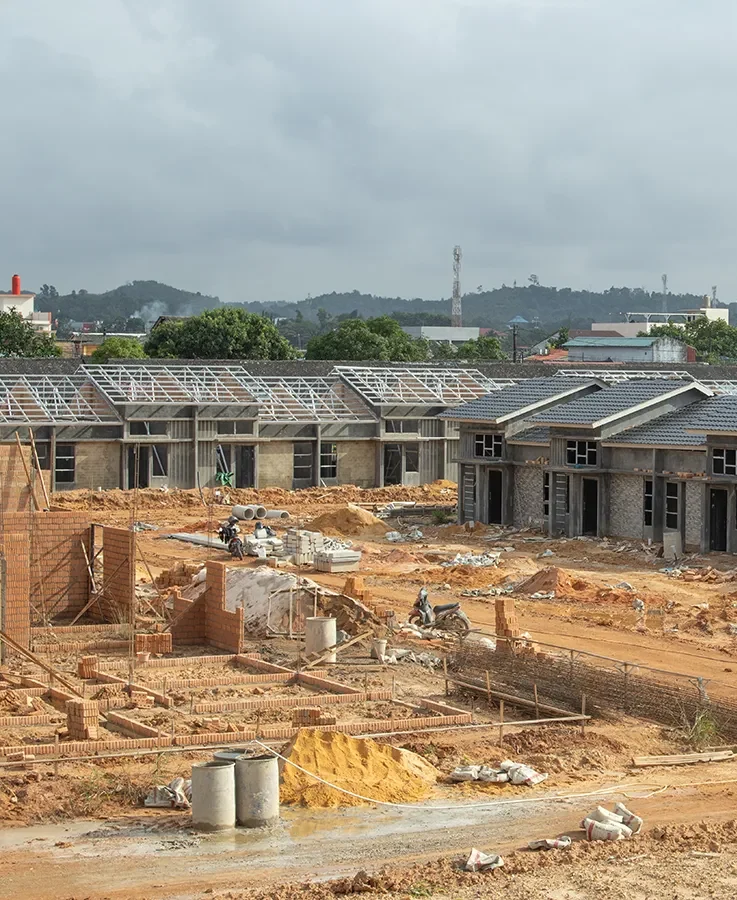 Construction site of a large building complex with multiple partially built rooms and roofing under development.